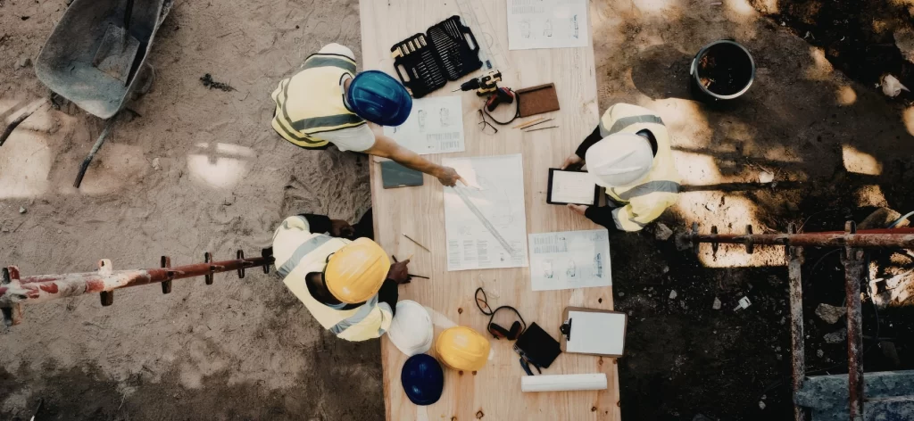 Building Contracting Company Dubai discussing a construction project with a client at a construction site