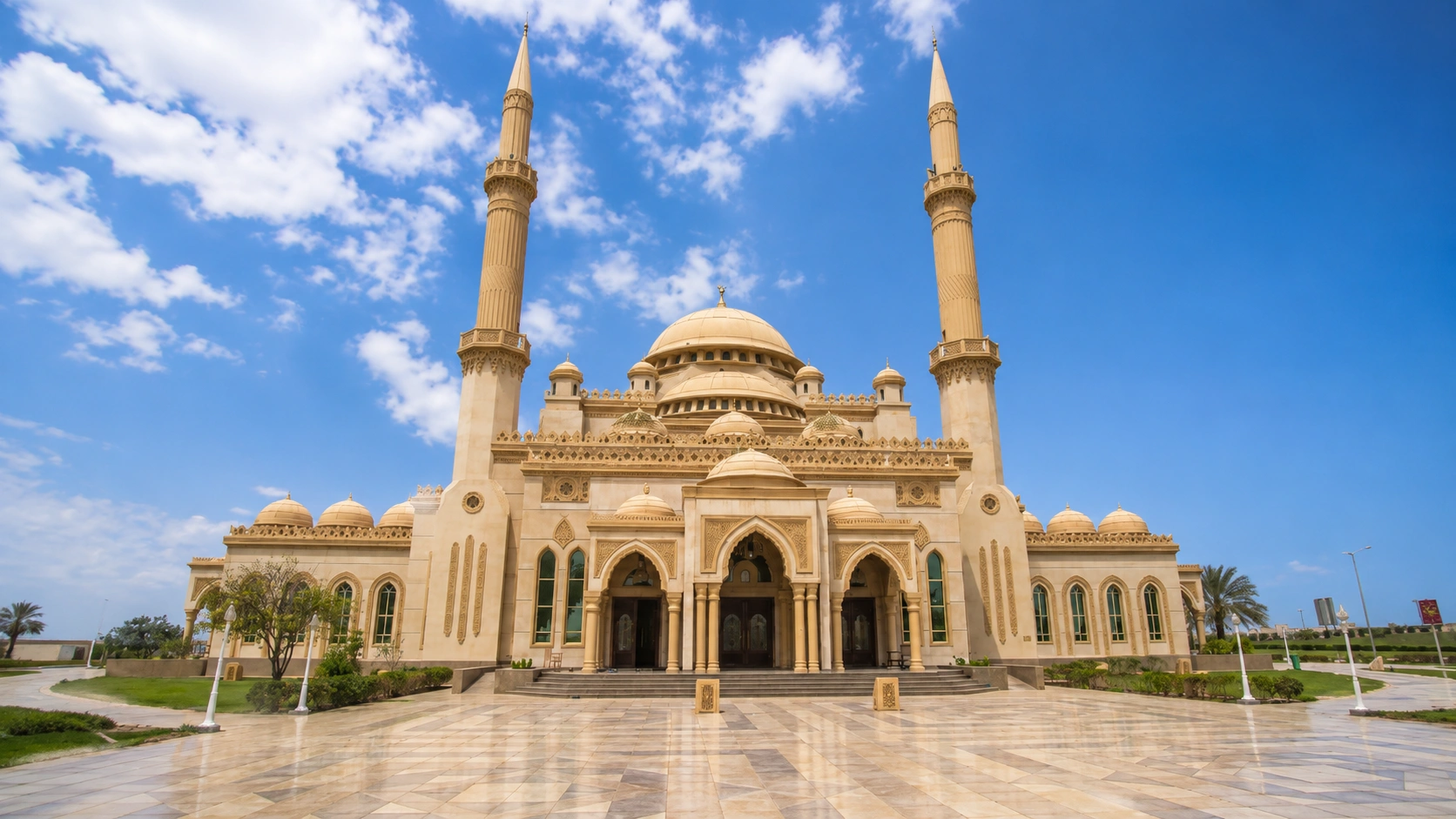 Al Rushd Mosque in Sharjah UAE featuring grand Islamic architecture, twin minarets, ornate domes, and a spacious courtyard.