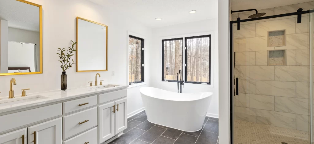 Bathroom renovation completed by renovation companies in Dubai featuring a freestanding bathtub, walk-in shower, and double vanity.