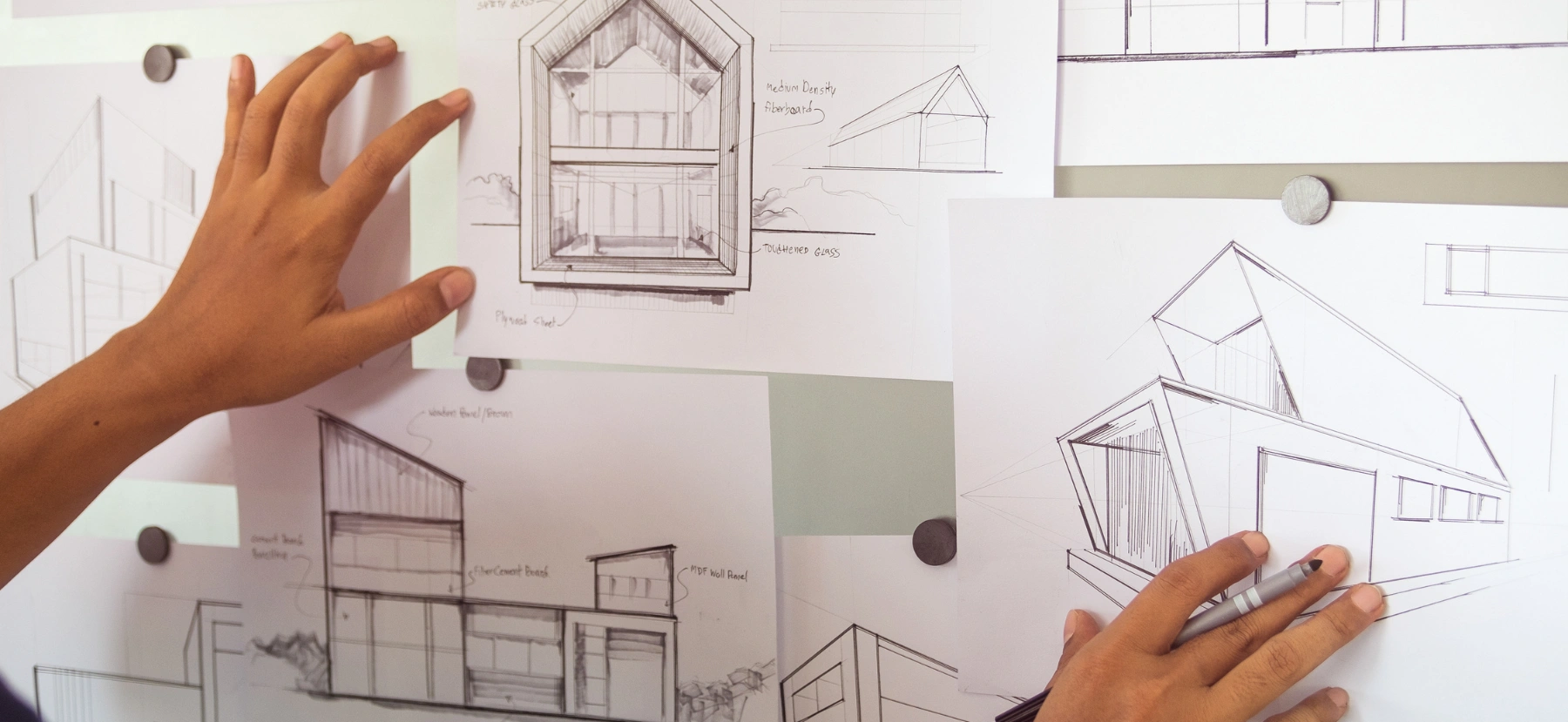 Architects reviewing building design sketches during the Design & Build planning process.